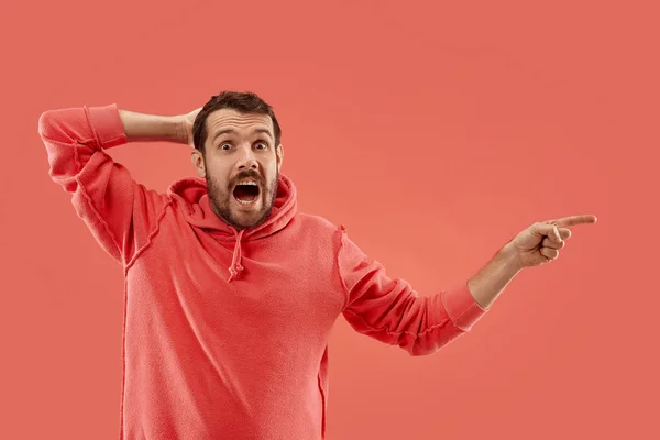 De jonge, aantrekkelijke man op zoek verrast geïsoleerd op koraal — Stockfoto