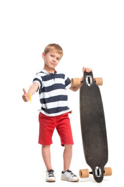 Beyaz arka planda izole bir şekilde kaykay süren sevimli bir çocuğun tam boy portresi.