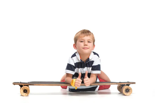 Портрет очаровательного мальчика, катающегося на скейтборде на белом фоне — стоковое фото