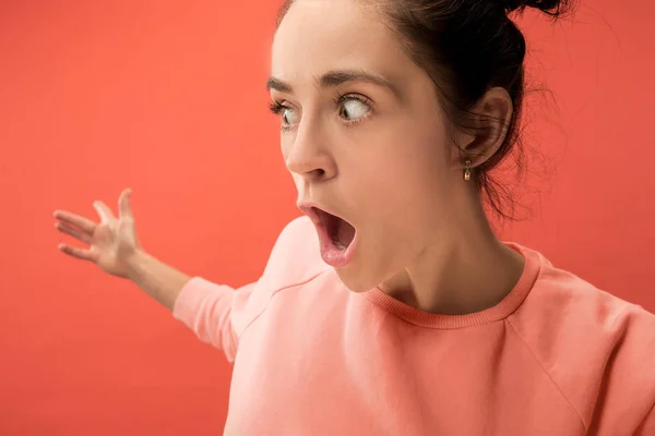 Hermosa mujer mirando sorprendido aislado en coral —  Fotos de Stock