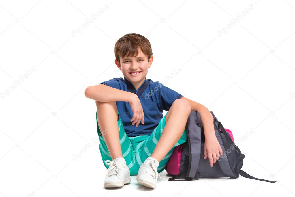 Full length portrait of cute little kid in stylish clothes looking at camera and smiling