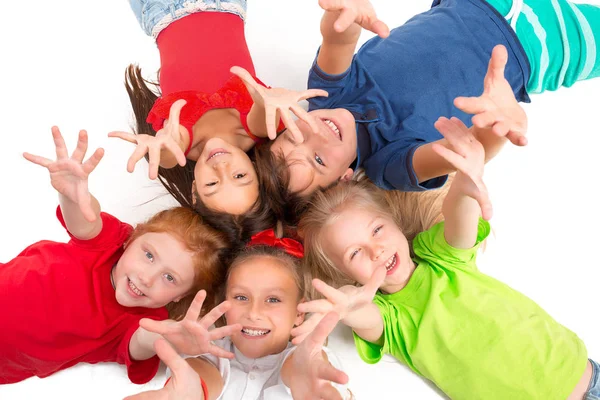 Primer plano de niños felices tumbados en el suelo en el estudio y mirando hacia arriba —  Fotos de Stock