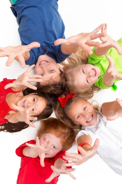 Close-up van gelukkige kinderen liggend op de vloer in de studio en opzoeken — Stockfoto