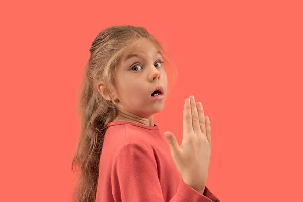 Schattig weinig verrast meisje in koraal jurk met lange haren glimlachen naar de camera — Stockfoto