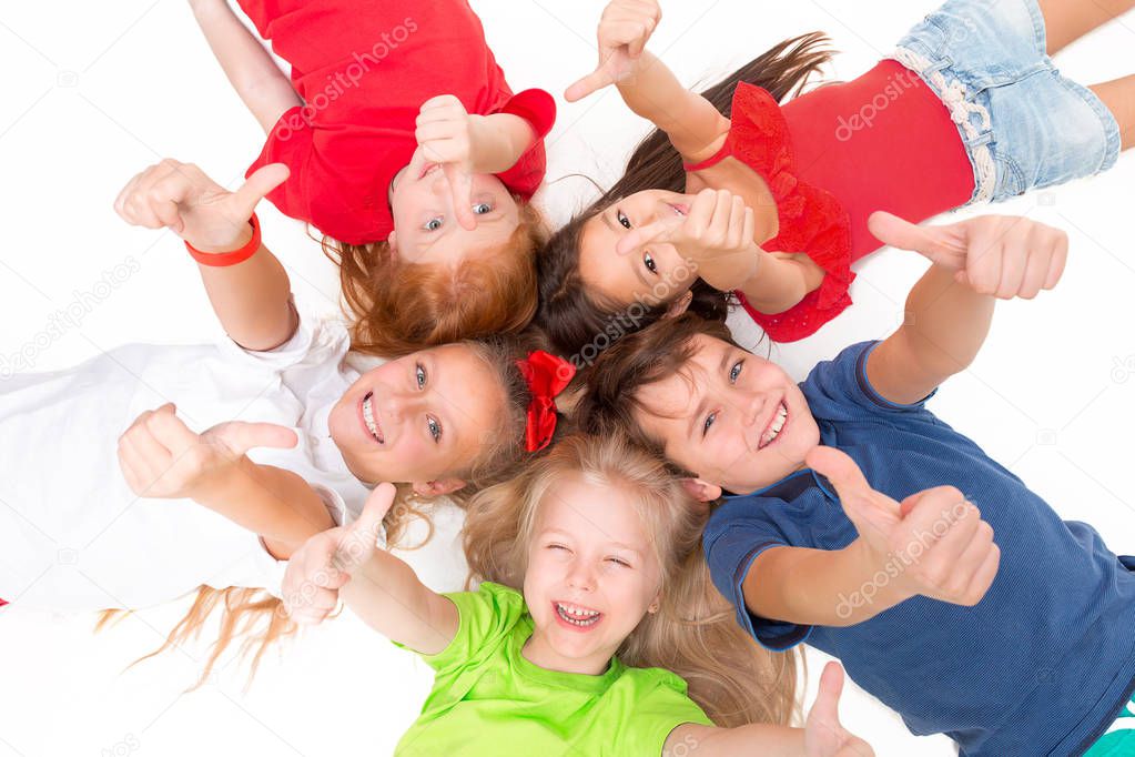 Close-up of happy children lying on floor in studio and looking up