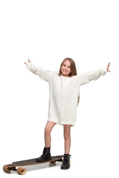 Retrato de larga duración de una adorable joven montando un monopatín aislado sobre fondo blanco —  Fotos de Stock
