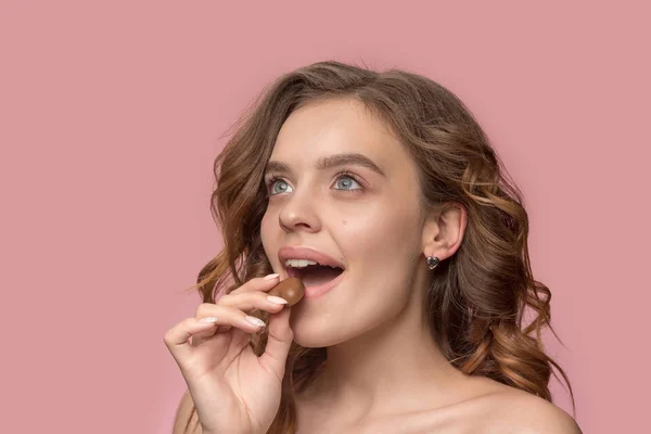 Portret van de schoonheid van een schattig meisje in wet om te eten een chocolade snoep — Stockfoto