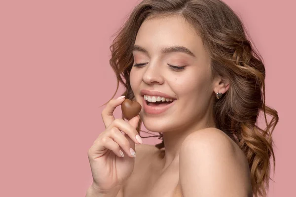 Retrato de beleza de uma menina bonita em ato para comer um doce de chocolate — Fotografia de Stock