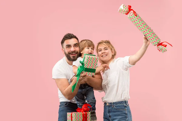 Happy family with kid together and smiling at camera isolated on pink — Stock Photo, Image