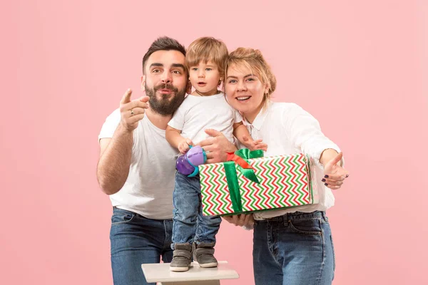 Happy family with kid together and smiling at camera isolated on pink — Stock Photo, Image