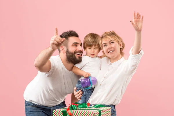 Happy family with kid together and smiling at camera isolated on pink — Stock Photo, Image