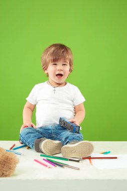 Yeşil arka plan üzerinde mutlu küçük çocuk portresi
