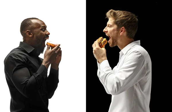 Män äter en hamburgare och donut på en svart och vit bakgrund — Stockfoto