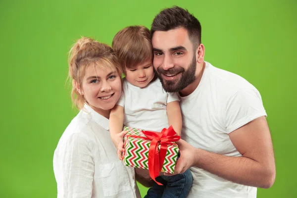 Happy family with kid together and smiling at camera isolated on green — Stock Photo, Image