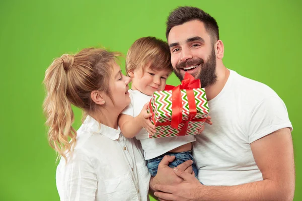 Familia feliz con el niño juntos y sonriendo a la cámara aislada en verde — Foto de Stock