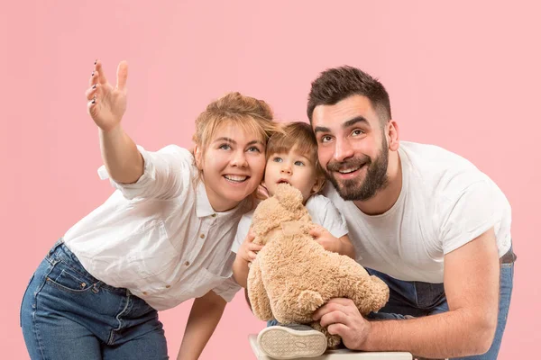 Família feliz com criança juntos e sorrindo para a câmera isolada em rosa — Fotografia de Stock