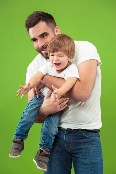 Happy family with kid together smiling at camera isolated on green — Stock Photo, Image