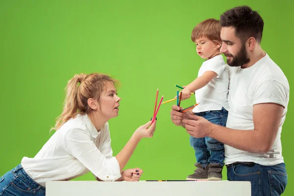 Glückliche Familie mit Kind zusammen und lächelnd in die Kamera isoliert auf grün — Stockfoto