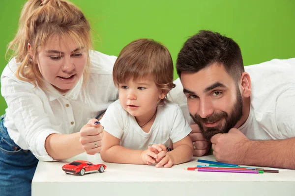 Happy family with kid together and smiling at camera isolated on green — Stock Photo, Image