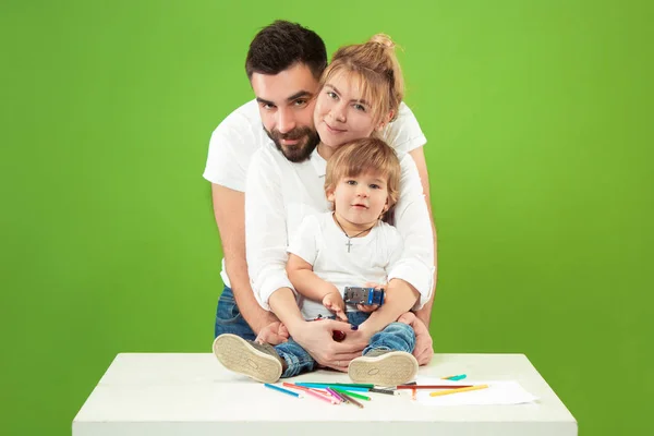 Lycklig familj med barn tillsammans och leende på kameran isolerad på grön — Stockfoto