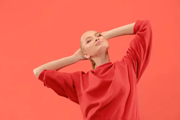 A mulher de negócios feliz de pé e sorrindo contra o fundo de coral . — Fotografia de Stock