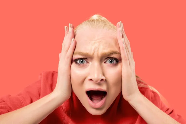 Die junge emotionale wütende Frau schreit auf Korallenatelier Hintergrund — Stockfoto
