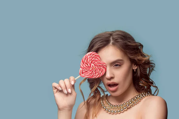 Beauty portrait of a cute girl in act to eat a candy — Stock Photo, Image