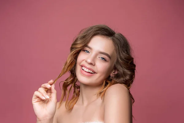 Nice young smiling woman with long wavy silky hair, natural make up looking at camera — Stock Photo, Image