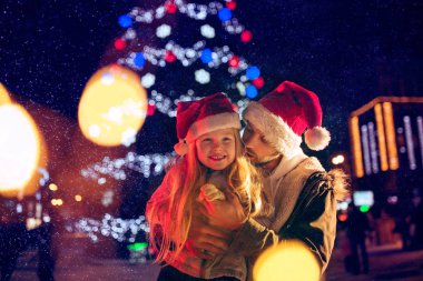 Aile, yılbaşı, bayram, sezon ve insanlar kavramı - mutlu aile şehir arka plan ve kar üzerinden