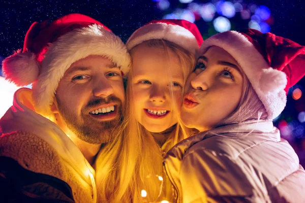 Familia, Navidad, vacaciones, temporada y concepto de personas - familia feliz sobre el fondo de la ciudad y la nieve —  Fotos de Stock