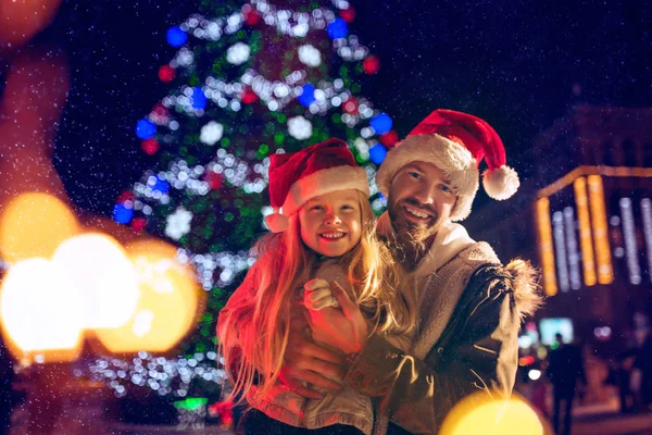 Familia, Navidad, vacaciones, temporada y concepto de personas - familia feliz sobre el fondo de la ciudad y la nieve —  Fotos de Stock