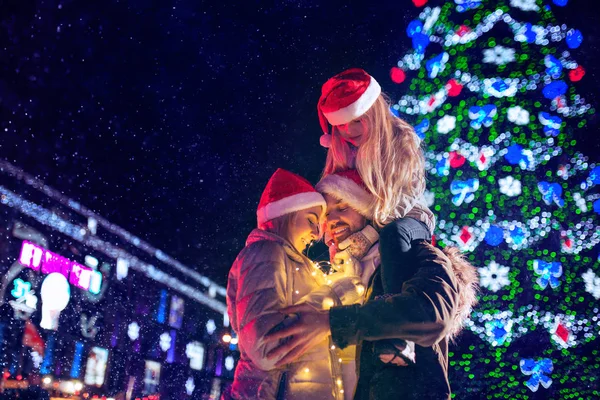 Familia, Navidad, vacaciones, temporada y concepto de personas - familia feliz sobre el fondo de la ciudad y la nieve —  Fotos de Stock