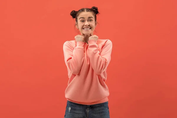 De gelukkige vrouw permanent en glimlachend tegen koraal achtergrond. — Stockfoto