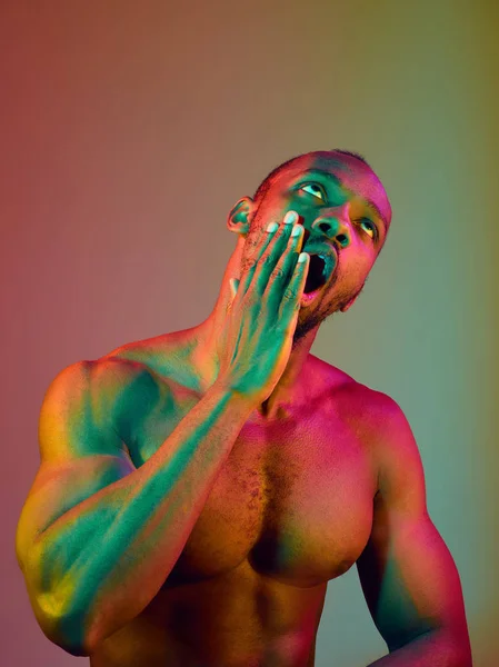 Close up portrait of a young naked african man looking at camera indoors