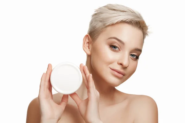 Leuk meisje voorbereiden om haar dag te beginnen. Zij is van toepassing moisturizer crème op gezicht. — Stockfoto