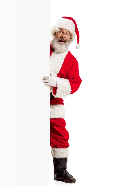 Szczęśliwy Santa Claus, wskazując na puste reklama transparent tło z miejsca kopii. Uśmiechający się Mikołaj, wskazując w biały znak puste — Zdjęcie stockowe