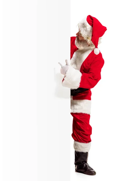 Happy santa claus zeigt auf leere Werbebanner Hintergrund mit Kopierfläche. Lächelnder Weihnachtsmann zeigt auf weißes Blanko-Schild — Stockfoto