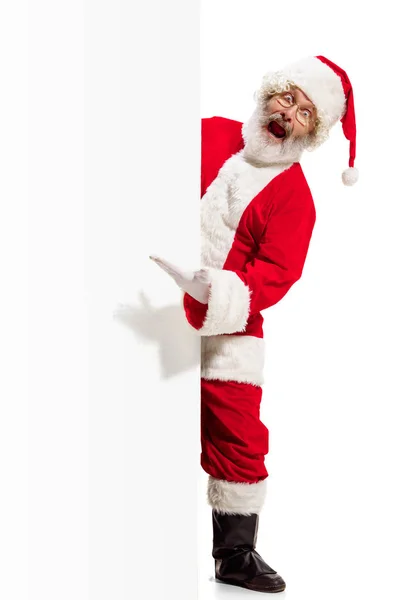 Happy santa claus zeigt auf leere Werbebanner Hintergrund mit Kopierfläche. Lächelnder Weihnachtsmann zeigt auf weißes Blanko-Schild — Stockfoto