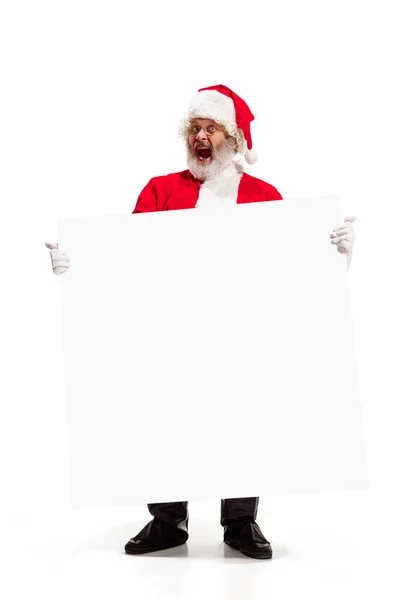 Happy Santa Claus pointing on blank advertisement banner background with copy space. Smiling Santa Claus pointing in white blank sign Stock Image