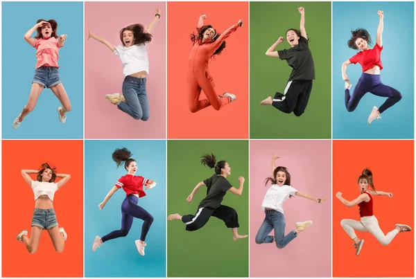 Liberdade em movimento. Mulher muito jovem pulando contra fundo laranja — Fotografia de Stock