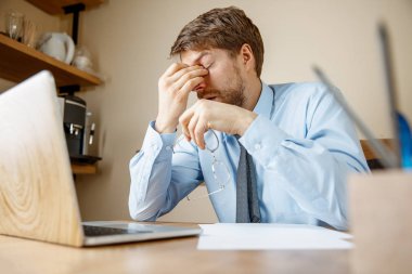 Hasta ve yorgun hissediyorum. Office çalışma evinde otururken kafasını masaj sinirli üzgün mutsuz hasta genç adam. Mevsimsel grip, pandemik influenza, hastalık önleme kavramı
