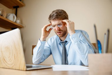 Hasta ve yorgun hissediyorum. Office çalışma evinde otururken kafasını masaj sinirli üzgün mutsuz hasta genç adam. Mevsimsel grip, pandemik influenza, hastalık önleme kavramı