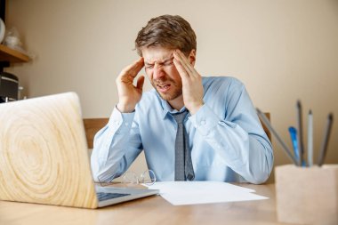 Hasta ve yorgun hissediyorum. Office çalışma evinde otururken kafasını masaj sinirli üzgün mutsuz hasta genç adam. Mevsimsel grip, pandemik influenza, hastalık önleme kavramı