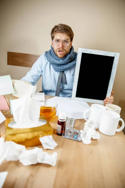 Hombre enfermo mientras trabajaba en la oficina, hombre de negocios atrapado resfriado, gripe estacional . — Foto de Stock