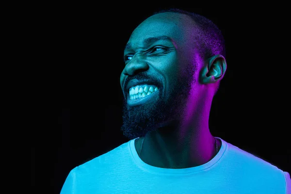 O retrato de néon de um jovem homem africano sorridente — Fotografia de Stock