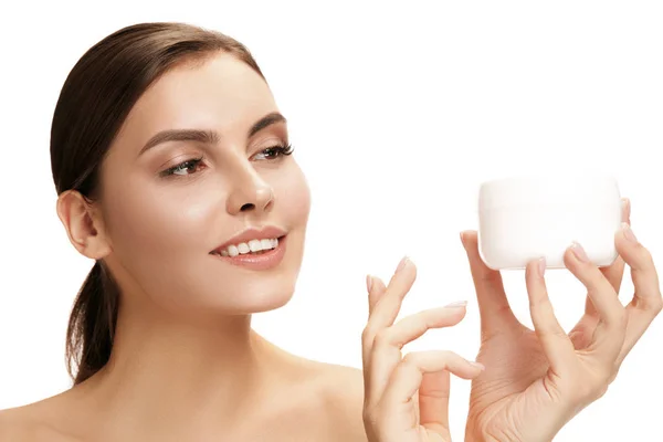 Leuk meisje voorbereiden om haar dag te beginnen. Zij is van toepassing moisturizer crème op gezicht. — Stockfoto