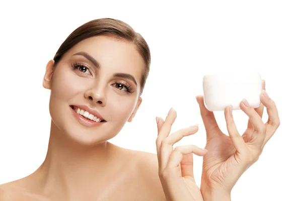 Leuk meisje voorbereiden om haar dag te beginnen. Zij is van toepassing moisturizer crème op gezicht. — Stockfoto