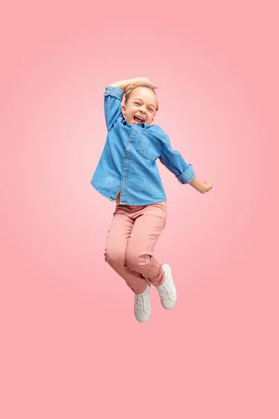 Jovem feliz caucasiano adolescente menina pulando no ar, isolado no fundo do estúdio rosa . — Fotografia de Stock