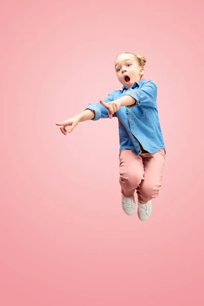 Joven feliz caucásico adolescente chica saltar en el aire, aislado en rosa estudio fondo . — Foto de Stock