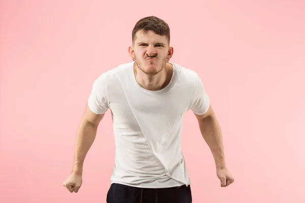 El joven hombre enojado emocional gritando en el fondo del estudio rosa — Foto de Stock